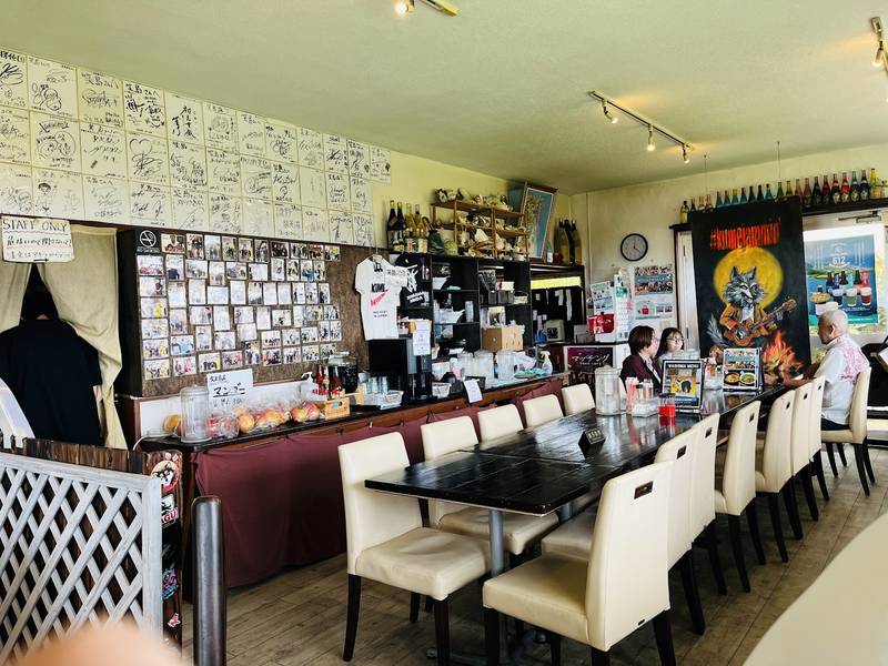 寄せ書きが壁一面に並ぶ、長テーブルの店内