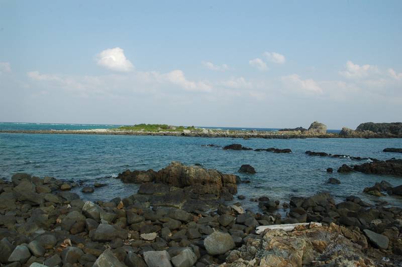 久米島の海岸、黒い岩場の向こうに広がる青い海